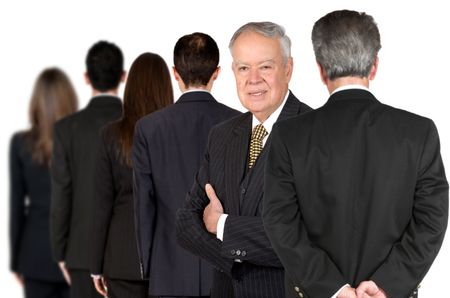business male senior facing the camera with his team behind him