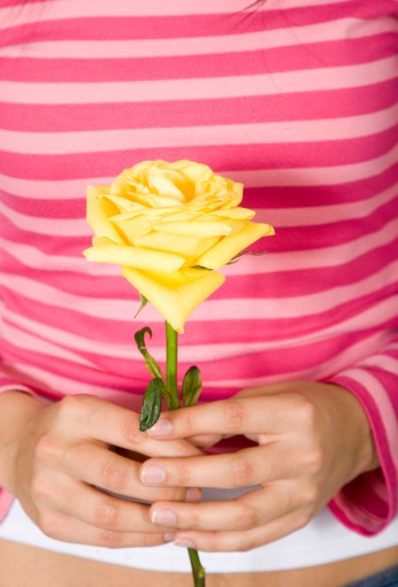 young girls hands holding a yellow rose