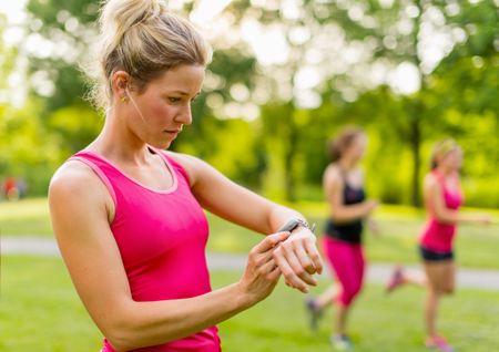 blond woman setting her timer before jogging