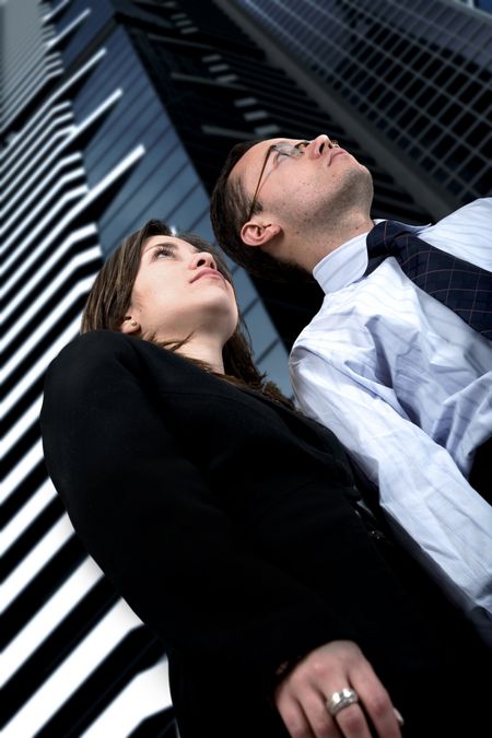 business partners full of expectations taken from a low angle with corporate buildings in the background