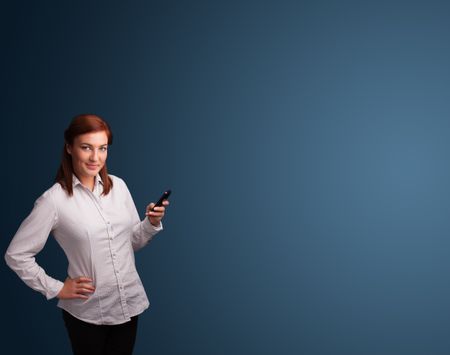 Pretty young woman standing and typing on her phone with copy space