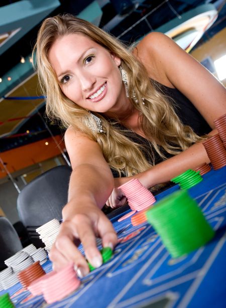 woman in a casino gambling on the roulette and smiling
