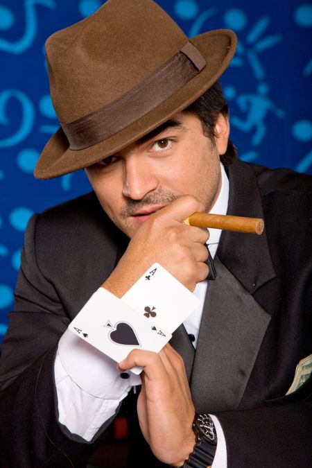 Poker player holding some cards and a cigar with a blue background