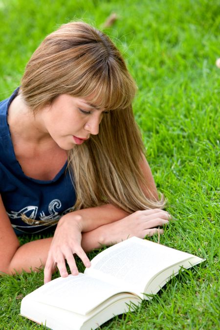 girl reading a book on the floor - outdoors