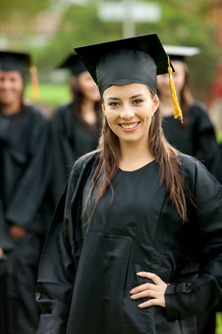 Smiley girl graduating standing outdoors