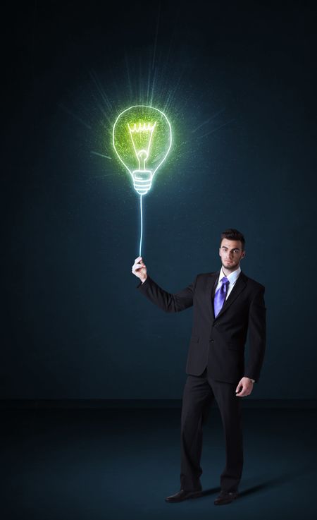 Businessman hold a shining idea bulb on a blue background