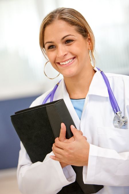 Female doctor at the hospital carrying a portfolio