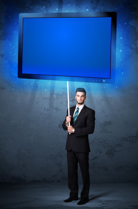Young businessman holding a big, blue shining tablet 