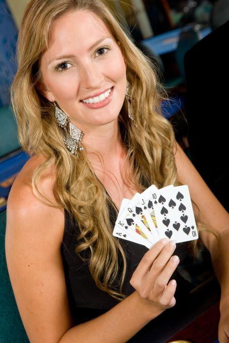 woman gambling at the casino showing a royal flush