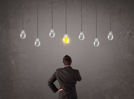 Businness guy in front of bright idea light bulbs concept