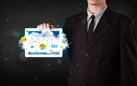 Person holding a white touchpad with cloud technology and charts