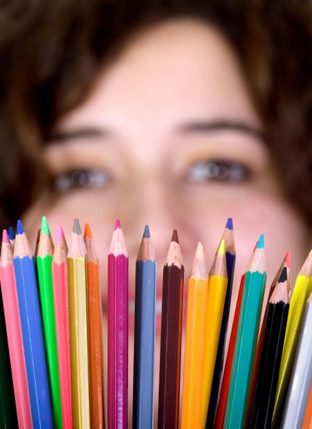 girl with color pencils in front of her - focus is on color pencils