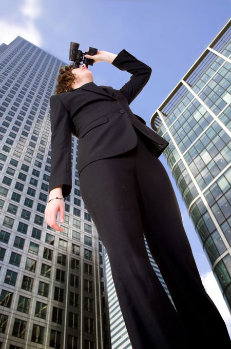 business vision - woman in corporate environment in perspective looking away with his binoculars