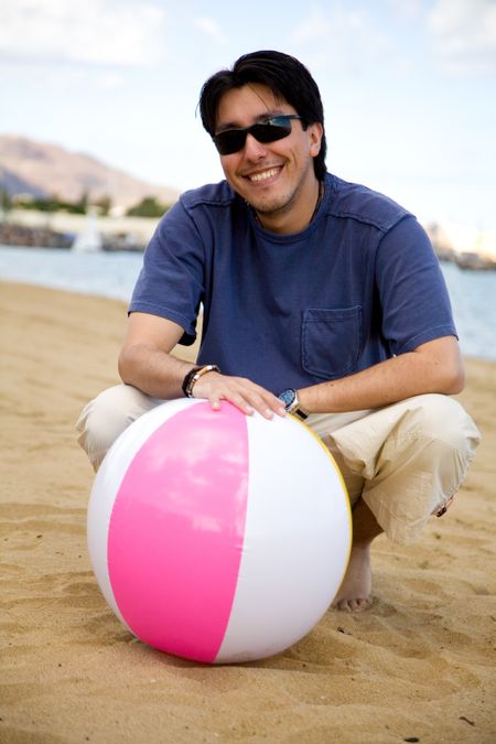 guy with a beachball smiling and wearing sunglasses