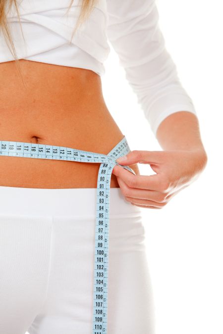 fit woman measuring her waist isolated over white