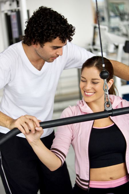 gym woman and her trainer doing exercise at the gym