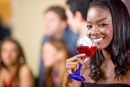 Black woman drinking a cocktail at a party