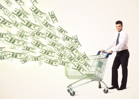 Businessman pushing a shopping cart and dollar bills coming out of it