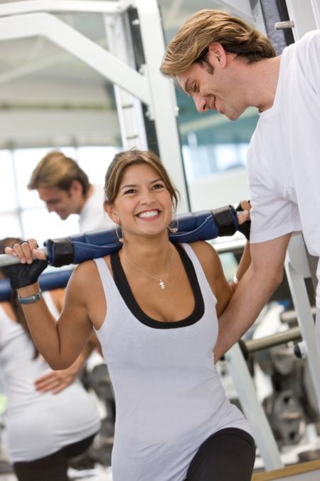 woman and her trainer doing exercise at the gym