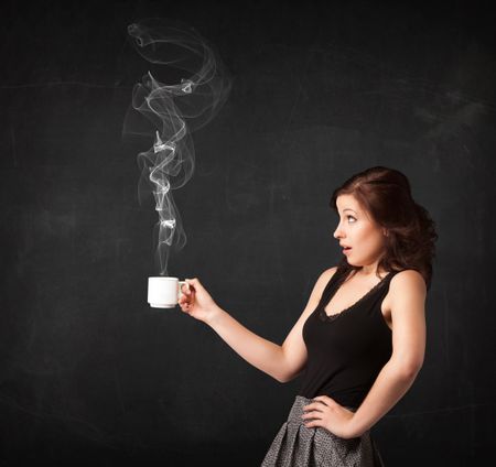 Businesswoman standing and holding a white steamy cup on a black background