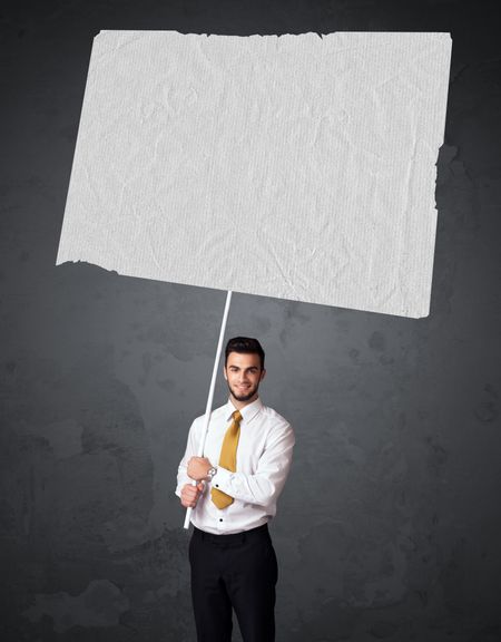 Young businessman holding a big blank booklet paper
