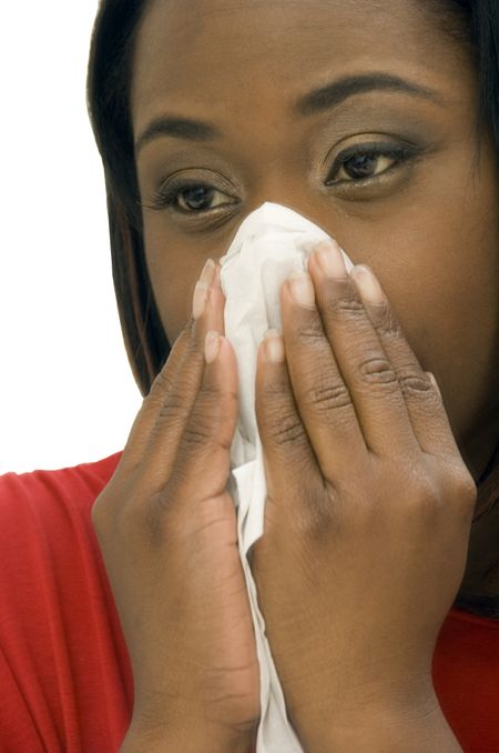 Young black woman covers her nose with tissue