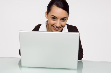 Businesswoman looking over the top of a laptop.
