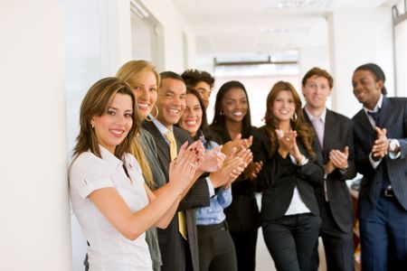 business team clapping in an office facing the camera