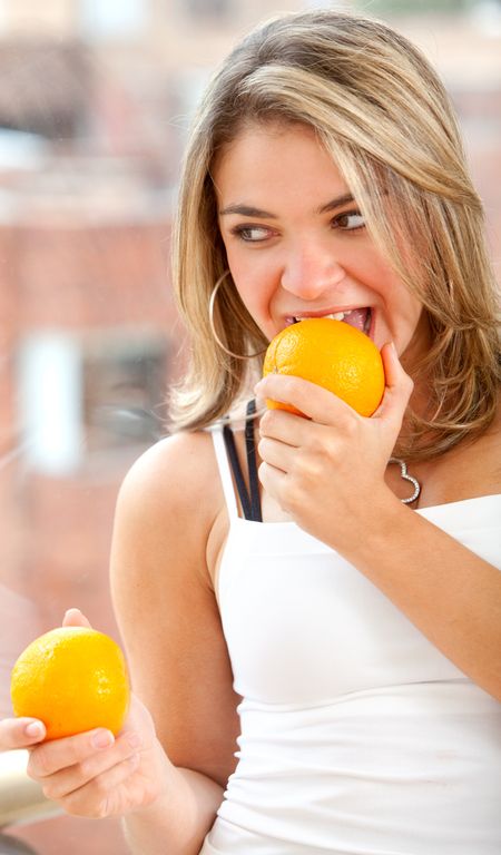 Beautiful woman eating some oranges