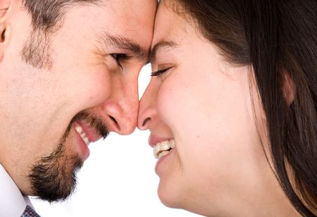 couple in love smiling and looking at each other - heads together over a white background