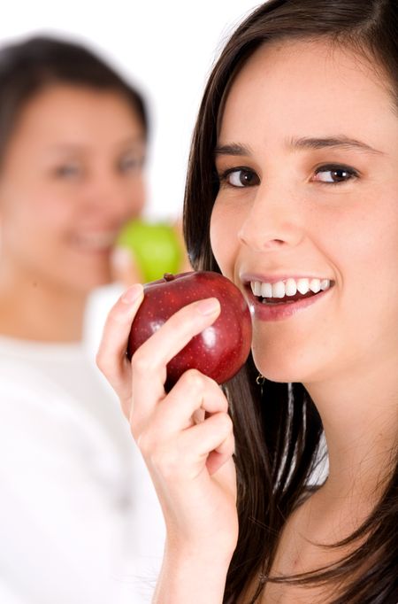 healthy girl smiling while eating an apple in her diet over a white background