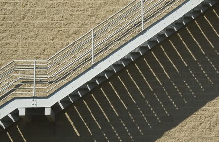 Exterior steel staircase with shadow pattern on brick wall of college athletic facility