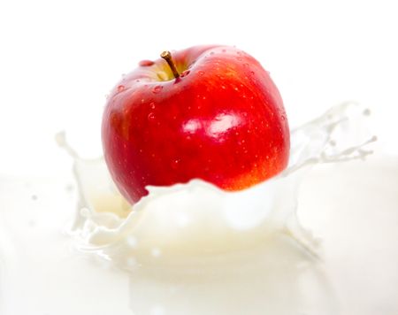 Apple falling into cream or milk and splashing
