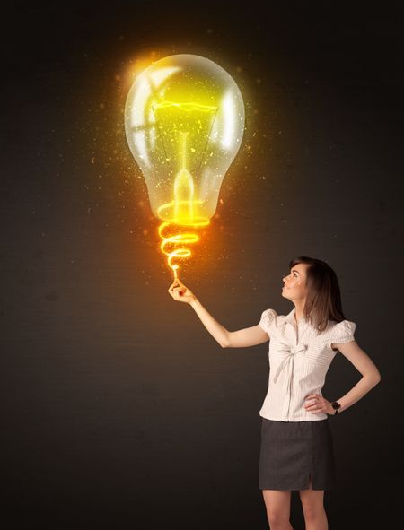 Businesswoman holding a shining, idea bulb