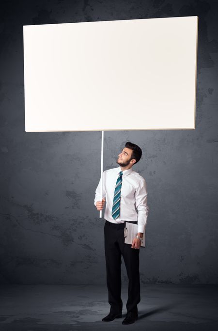Young businessman holding a blank whiteboard