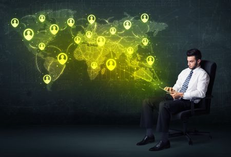 Businessman in office with tablet and social network world map concept on background