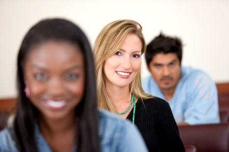 Group of university students sitting in a classroom smiling