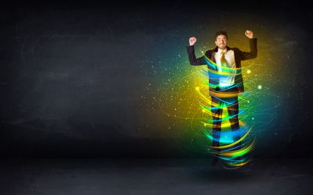 Excited business man jumping with energy colourful lines around him