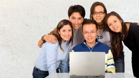 Casual group of students smiling in a classroom with a blackboard in the background with the words back to school