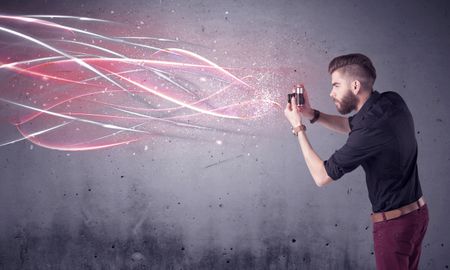 A stylish funny hipster person holding a vintage camera and taking photographs illustrated with glowing red, white lines concept