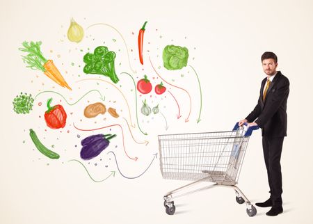 Businessman pushing a shopping cart and healthy vegetables coming out of it
