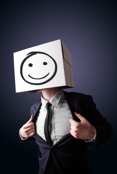 Businessman standing and gesturing with a cardboard box on his head with smiley face