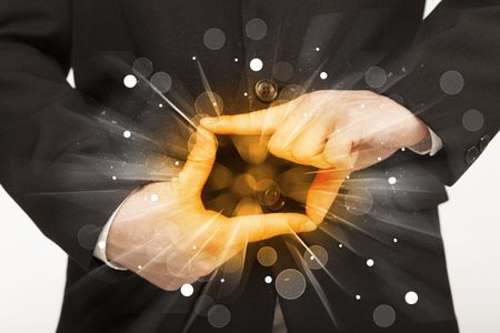 Hands creating a form with yellow shines in the center