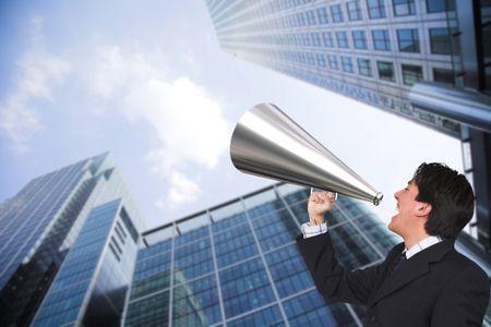 Business man outside corporate building with a megaphone