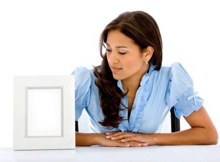 Woman looking at an empty photo frame isolated