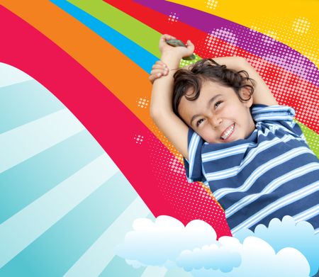 Happy smiley boy lying over a rainbow