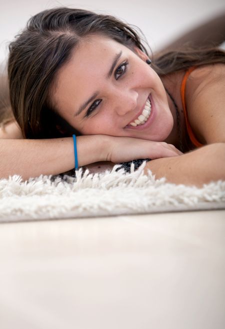 Smiley girl lying on the floor over a rug
