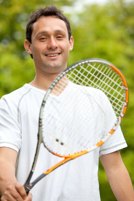 Young man holding a tennis racket outdoors