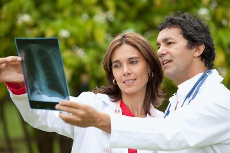male and female doctors watching an x-ray outdoors
