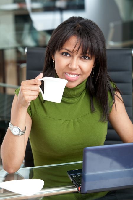 Business woman in her office drinking her coffee